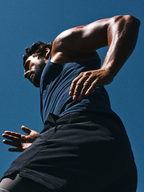Man stretching against a blue sky