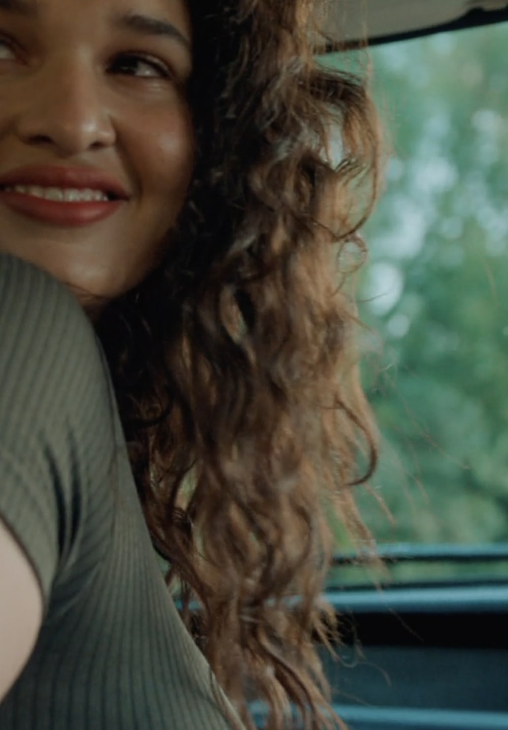 Close-up of a woman smiling in a car